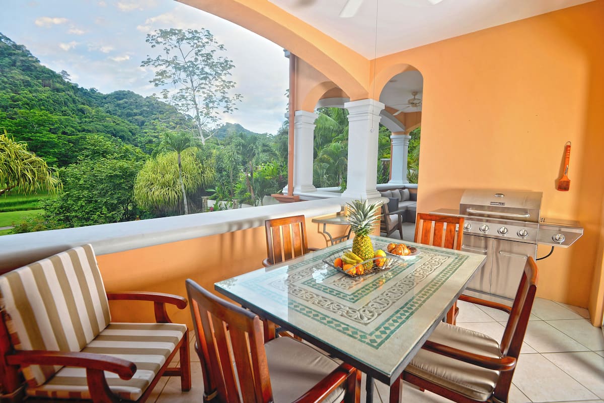 Un espace repas comprenant une table, des chaises et un barbecue.