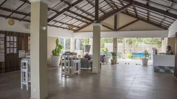 A spacious lobby with high ceilings, large windows, and a reception desk.