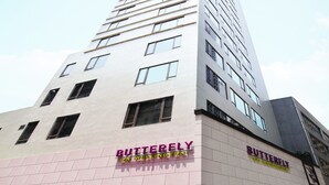 A high-rise building with multiple floors, featuring a prominent sign for 'Butterfly on Wellington' on the lower levels. - Butterfly on Wellington, Central (Hong Kong)