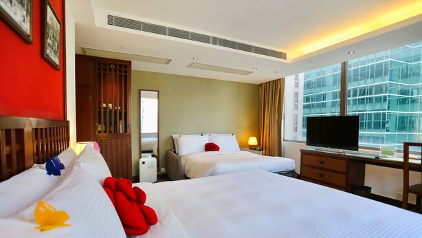A hotel room with two beds, a TV, a desk, and a large window with a view of a building. - Butterfly on Wellington, Central (Hong Kong)
