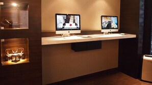 Two Apple iMac computers on a white shelf in a room with wooden walls and a dark floor. - Butterfly on Wellington, Central (Hong Kong)