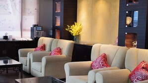 A modern living room with two beige sofas, a glass coffee table, and a dark wooden side table. - Butterfly on Wellington, Central (Hong Kong)