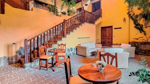 A cozy indoor area with a wooden staircase, stone steps, and a mix of wooden and wicker furniture. - Hotel Rural Bentor (Los Realejos)