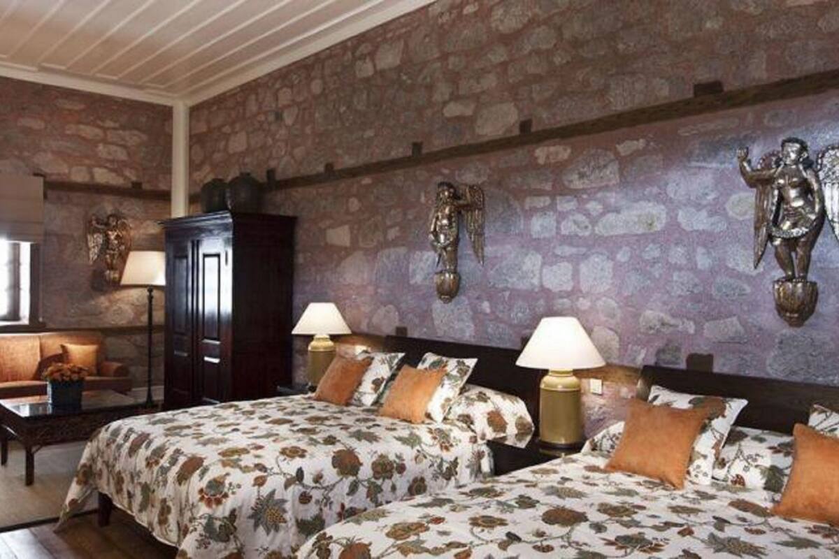 Ein Zimmer mit zwei Betten, einem Sofa und einem Schrank.