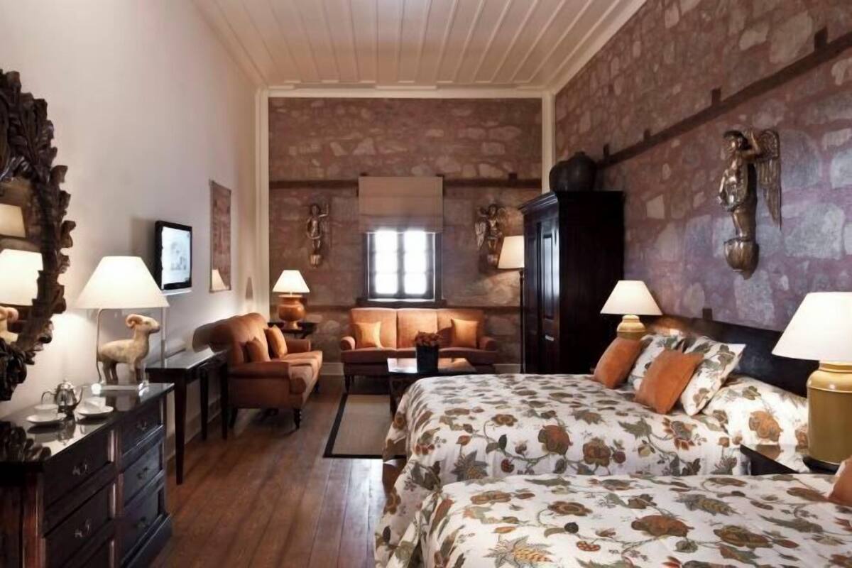 Ein gemütliches Zimmer mit Bett, Sofa, Schreibtisch und Kommode.