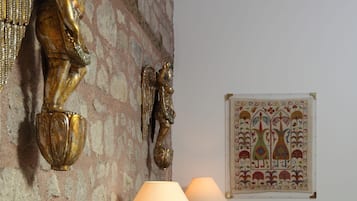 Una habitación con una cama, cabecera de madera, lámpara de pared y decoración mural.