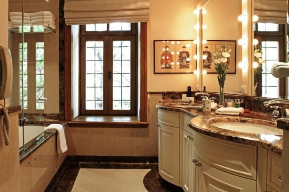 A bathroom with a bathtub, a sink, a vanity, and a large mirror.