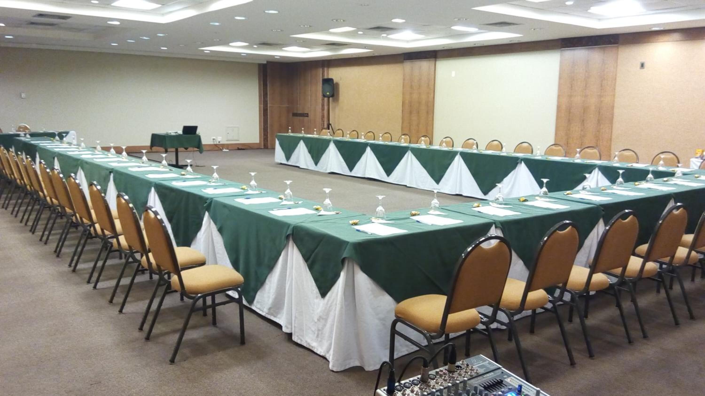 A conference room with long tables, chairs, and a podium.