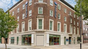A brick building with 'Travelodge' signage, large windows, and a corner entrance. - Travelodge London Central Waterloo (London)