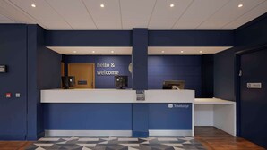 A reception desk with a 'hello & welcome' sign, a private label, and the Travelodge logo. - Travelodge London Central Waterloo (London)