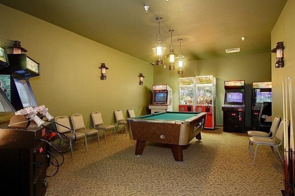A pool table in a room with arcade games and a pool table. - Whitefish Lodge and Suites (Crosslake)