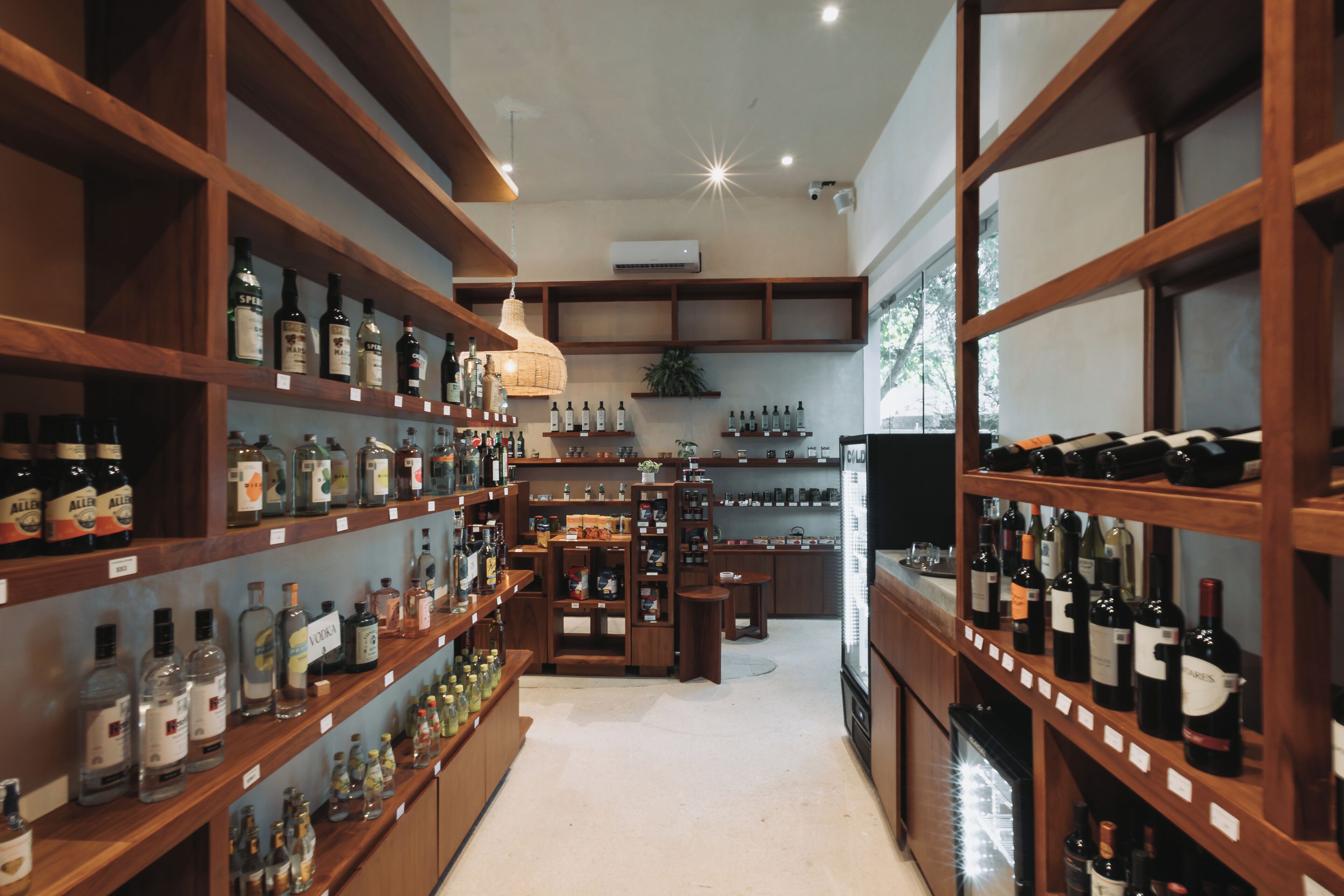 A liquor store with wooden shelves stocked with various bottles.
