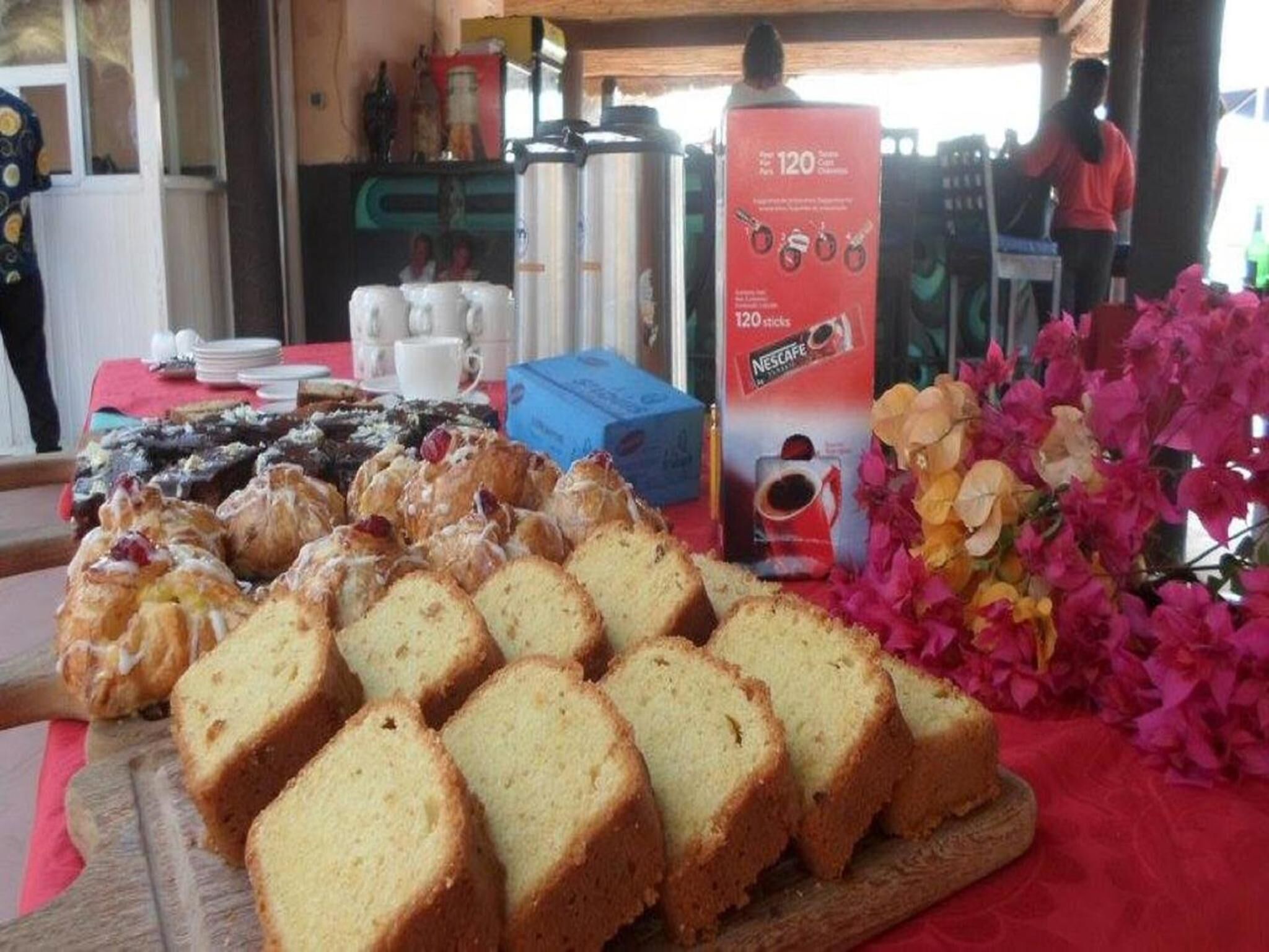 Un buffet per la colazione con diversi dolci e una postazione per caffè Nescafe.