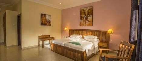 A hotel room with a wooden bed, two bedside tables, a chair, and a painting on the wall.