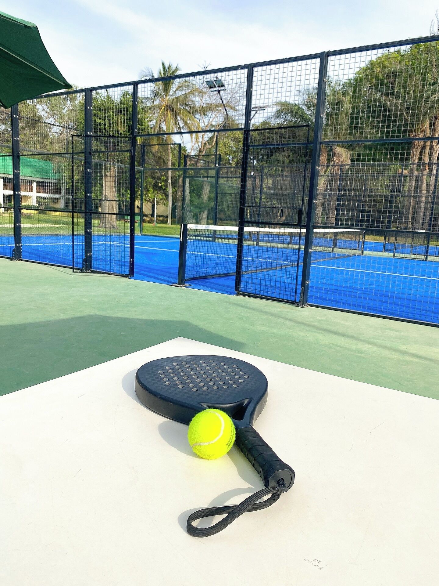 Una cancha de tenis con una red, una raqueta y una pelota.