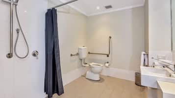 A modern bathroom with a shower, toilet, and sink.
