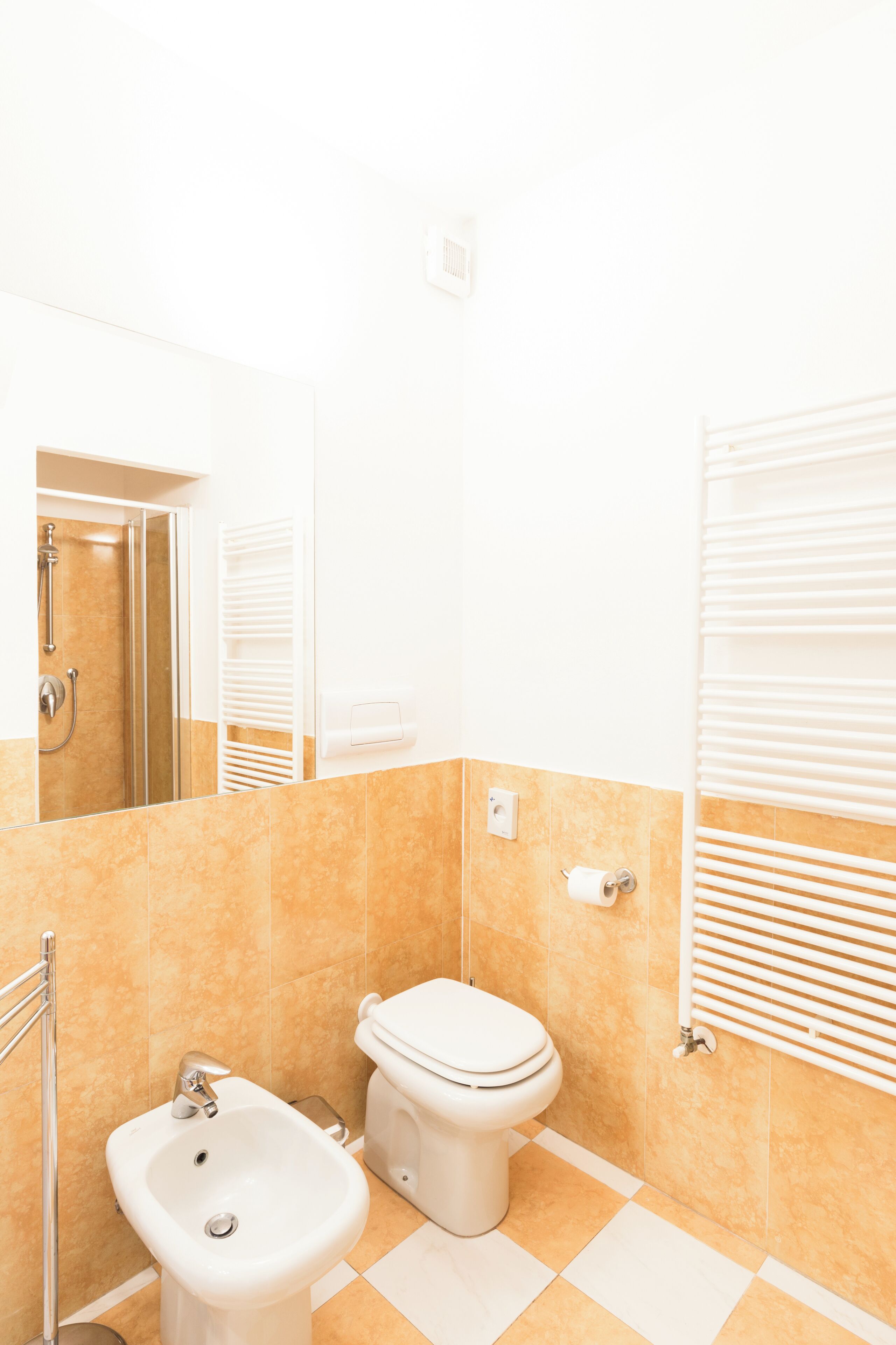 Ein Badezimmer mit Bidet, Toilette und Spiegel.