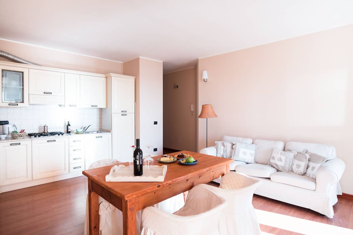 A compact living space with a kitchenette, a dining table, and a sofa.