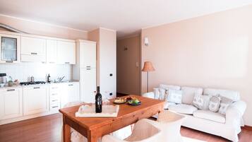A compact living space with a kitchenette, a dining table, and a sofa.
