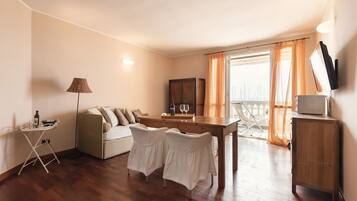 Suite, Balkon, Meerblick | Wohnbereich | Flachbildfernseher, Bücher