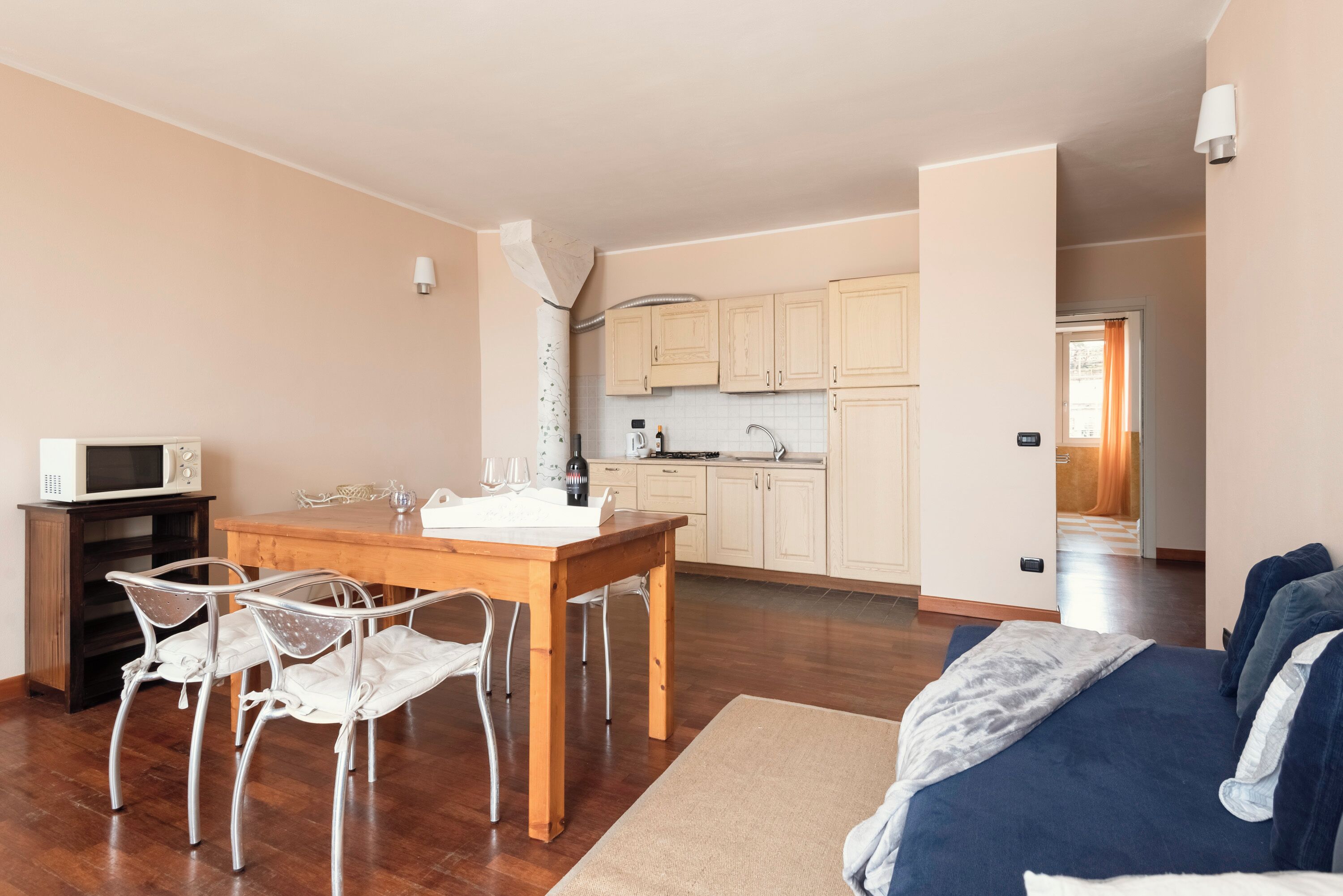 Un espacio habitable compacto con comedor, kitchenette y sofá.