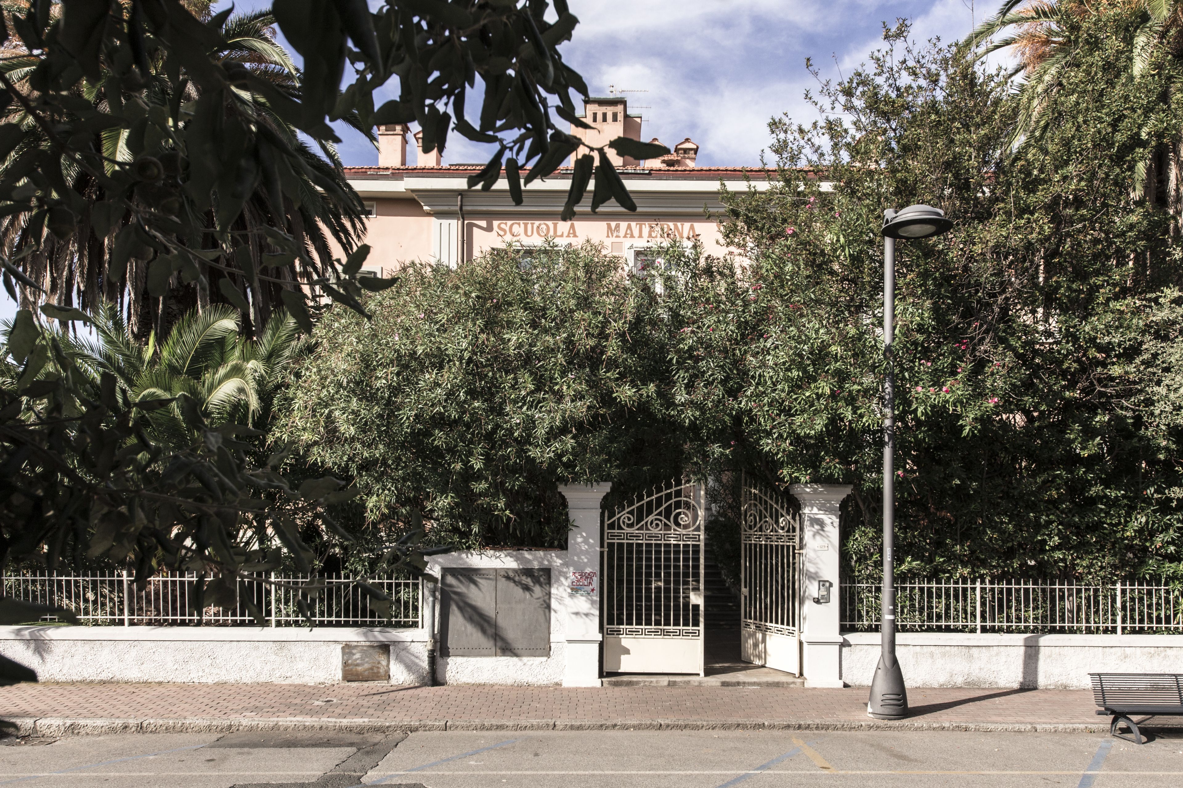 Un bâtiment sur lequel on peut lire l’inscription « SCUOLA MATTERNA » et dont l’entrée est fermée par un portail.