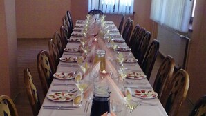 A long dining table set with plates, cutlery, and glasses, arranged for a meal.