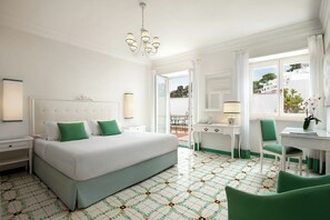 A hotel room with a bed, a desk, a chair, and a view of the outside. - Sina Flora Capri (Capri)