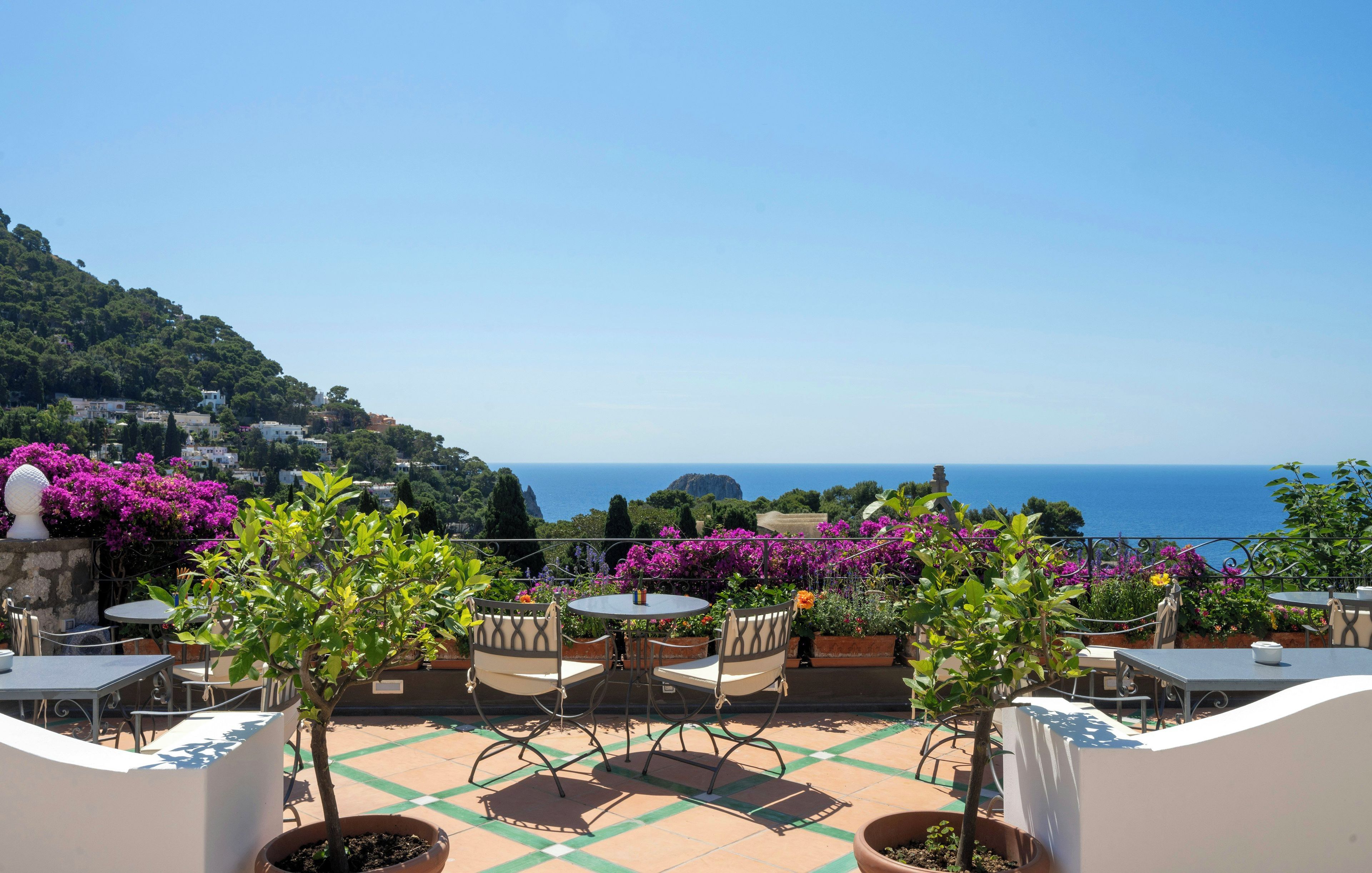 A terrace with outdoor seating and a view of the sea.