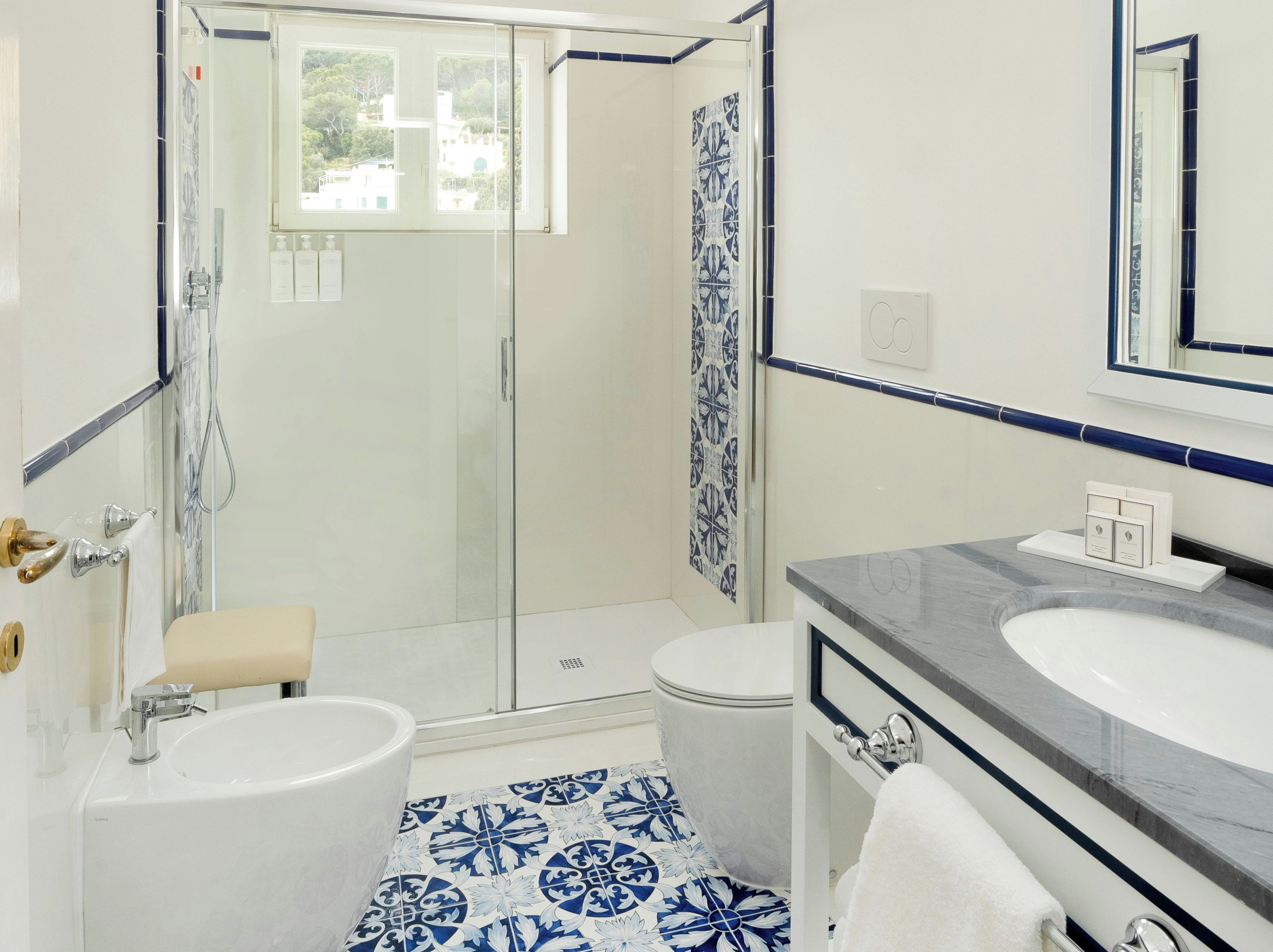 A bathroom with a shower, toilet, and sink.