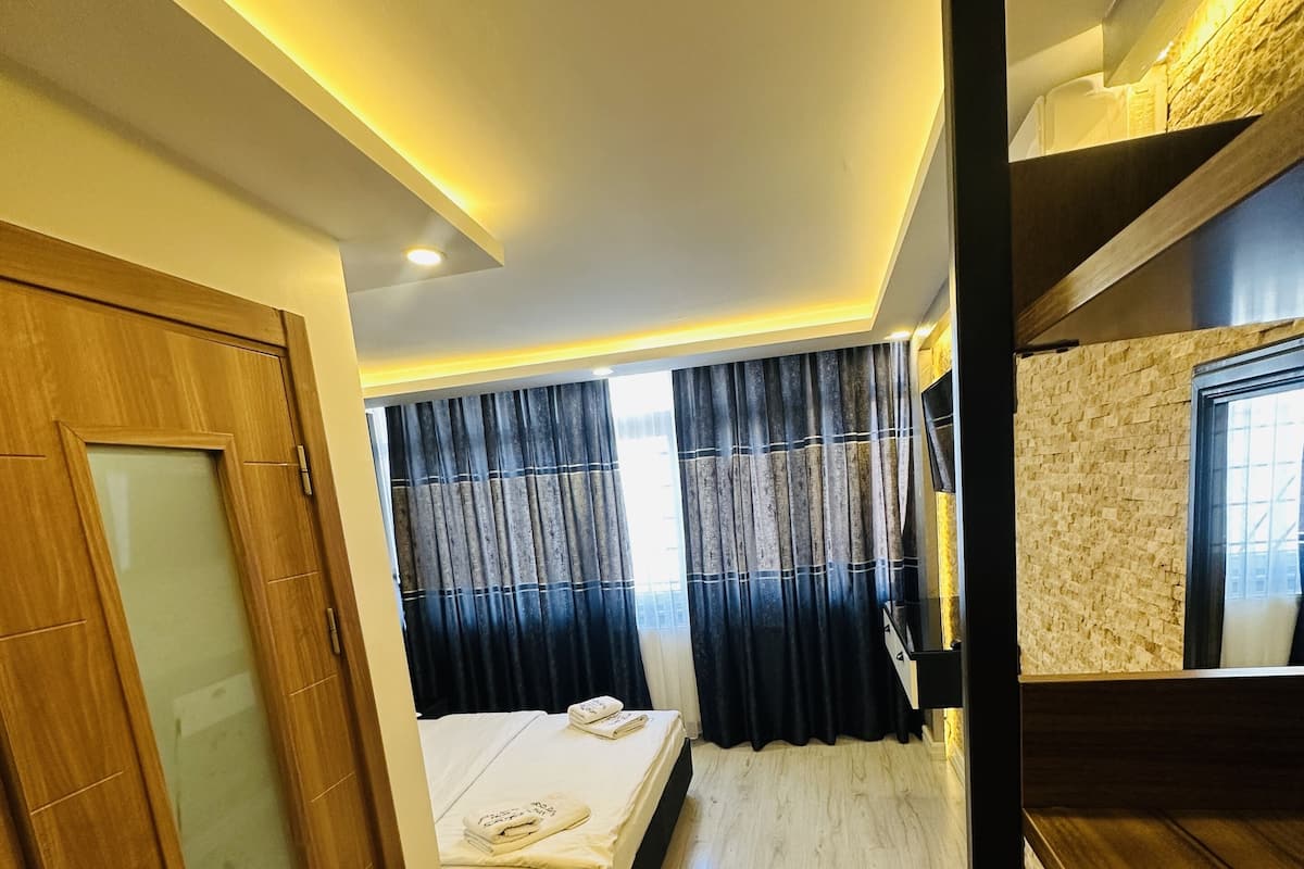 A hotel room with a bed, a desk, a wardrobe, and a bathroom.