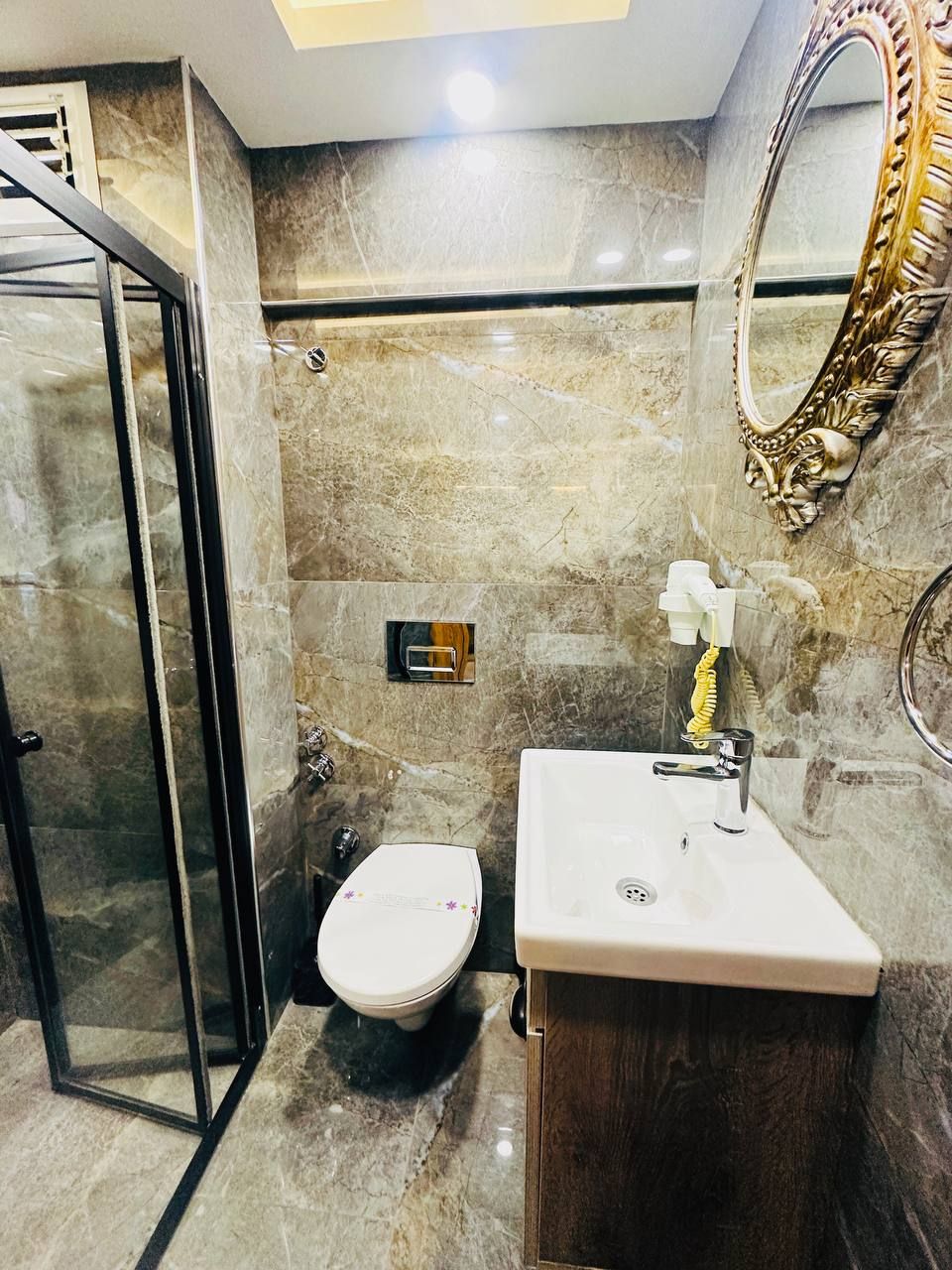 Une salle de bain avec une douche à parois de verre, des toilettes et un lavabo avec un miroir.