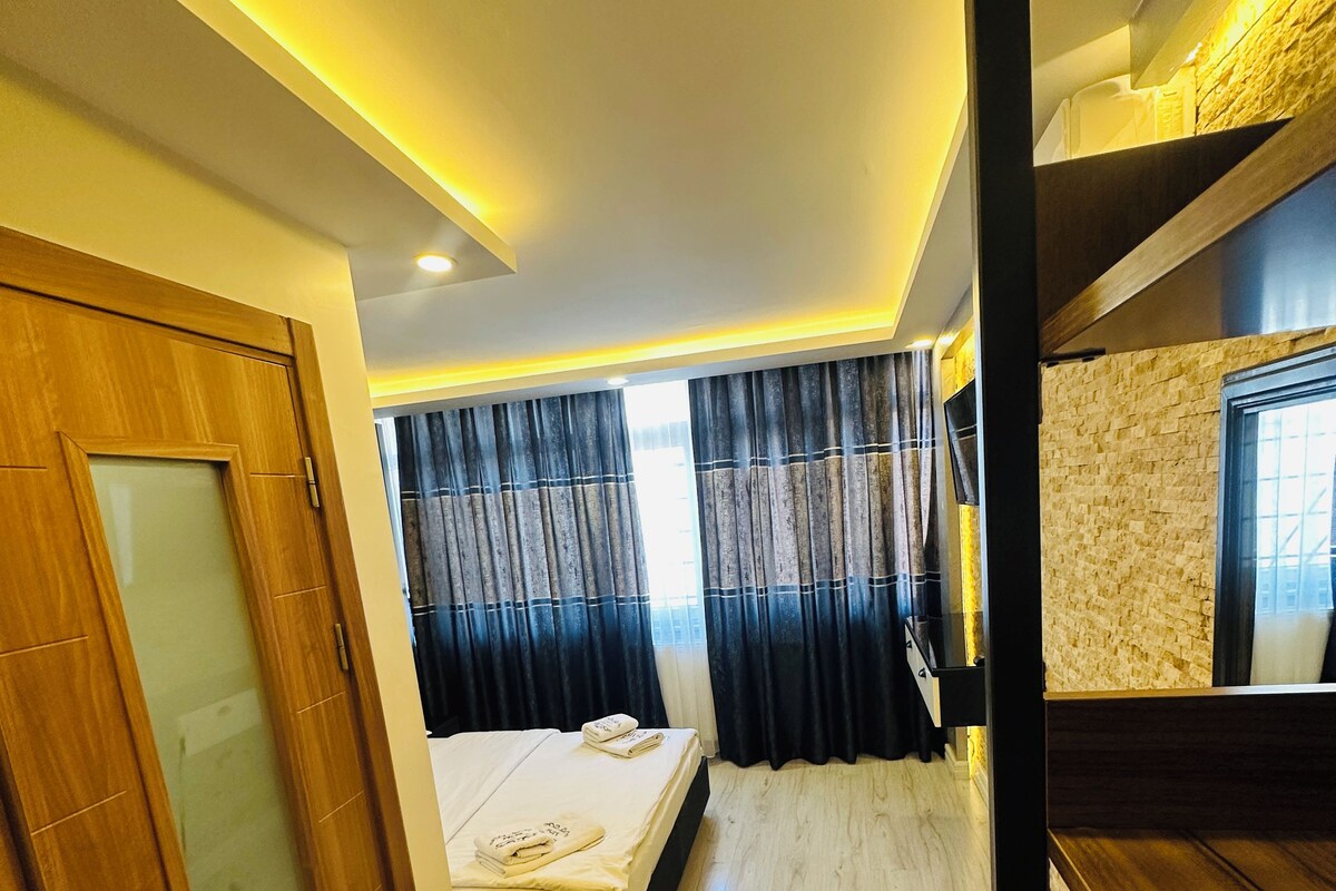 A hotel room with a bed, a desk, a wardrobe, and a bathroom.