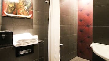 Een badkamer met douche, toilet en wastafel.
