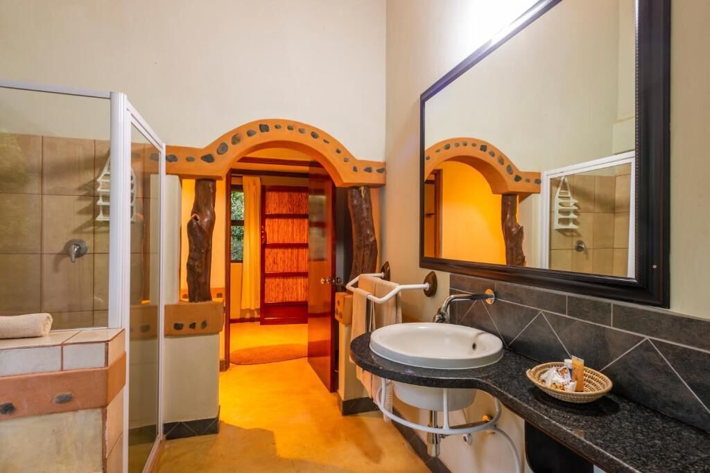 Un baño con un vano curvo, un lavabo y un espejo.