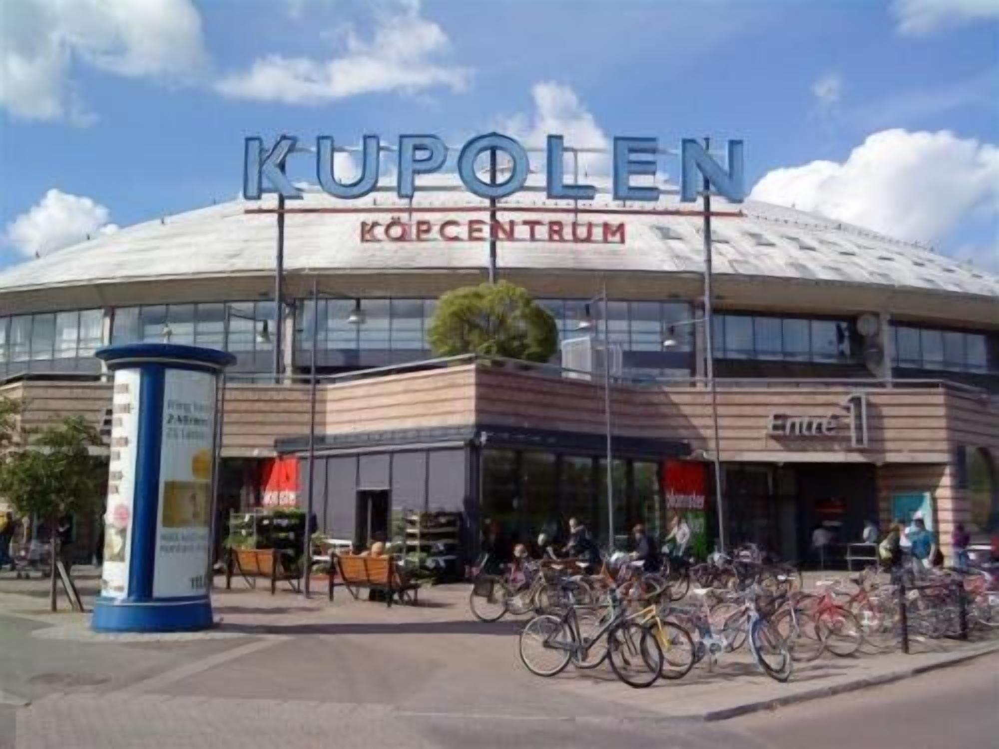 A modern building with a large sign reading "KUPOLEN KOPCENTRUM".