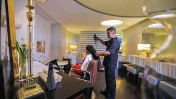 A modern hotel room with a sitting area, a vanity, and a mirror.