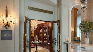 A grand entrance with a chandelier, a large mirror, and a display of luxury items. - The Leela Palace New Delhi (New Delhi)