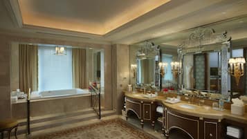 A luxurious bathroom with a large bathtub, double sinks, and ornate mirrors.