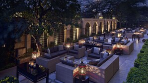 An outdoor lounge area with sofas, tables, and decorative lanterns. - The Leela Palace New Delhi (New Delhi)