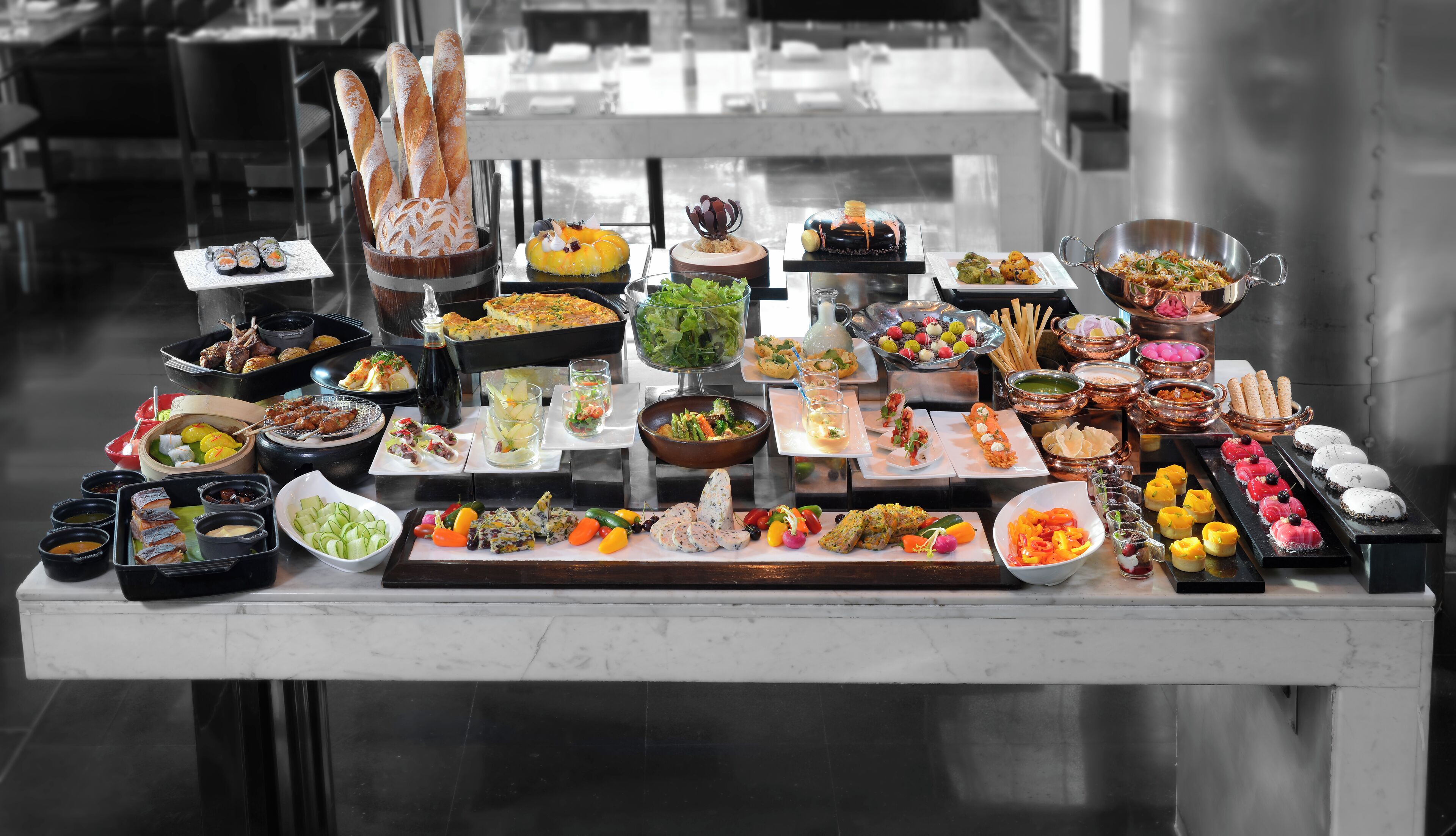 A buffet table with various food items and dishes.