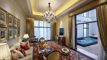 A luxurious hotel room with a large window, a chandelier, a sofa, a coffee table, and a pool view.