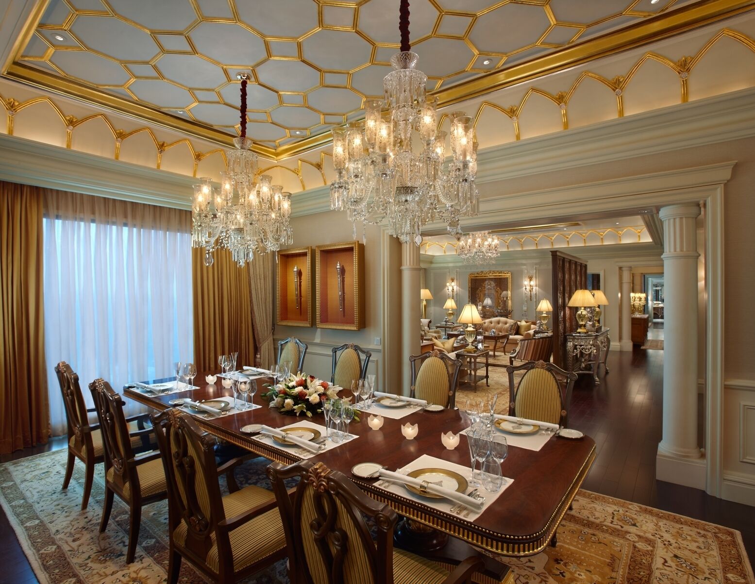 A formal dining room with a large table set for a meal, surrounded by ornate chairs.