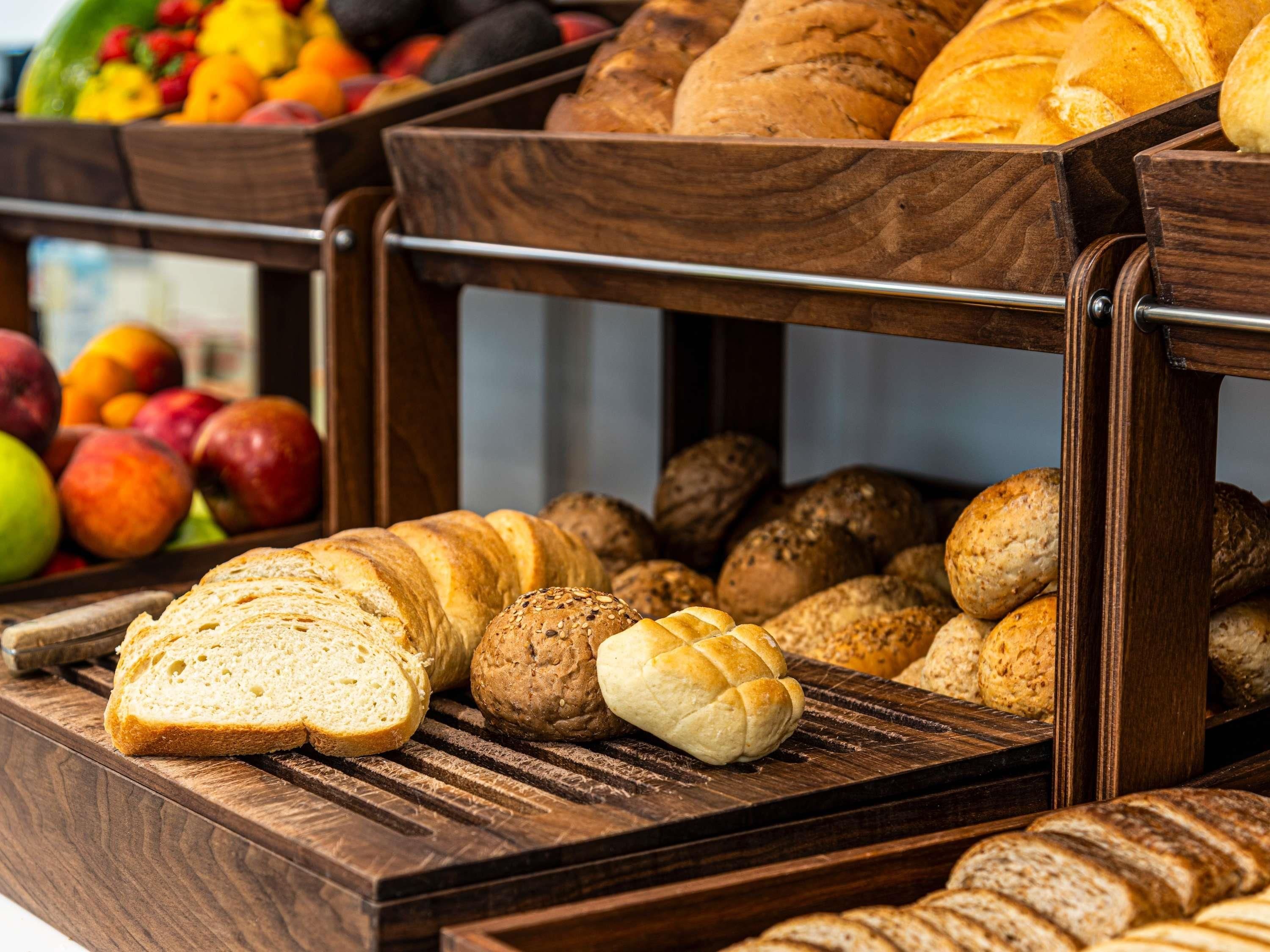 A wooden display case with various breads and pastries.