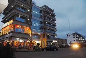 A multi-story hotel with a modern design, featuring balconies and large windows.