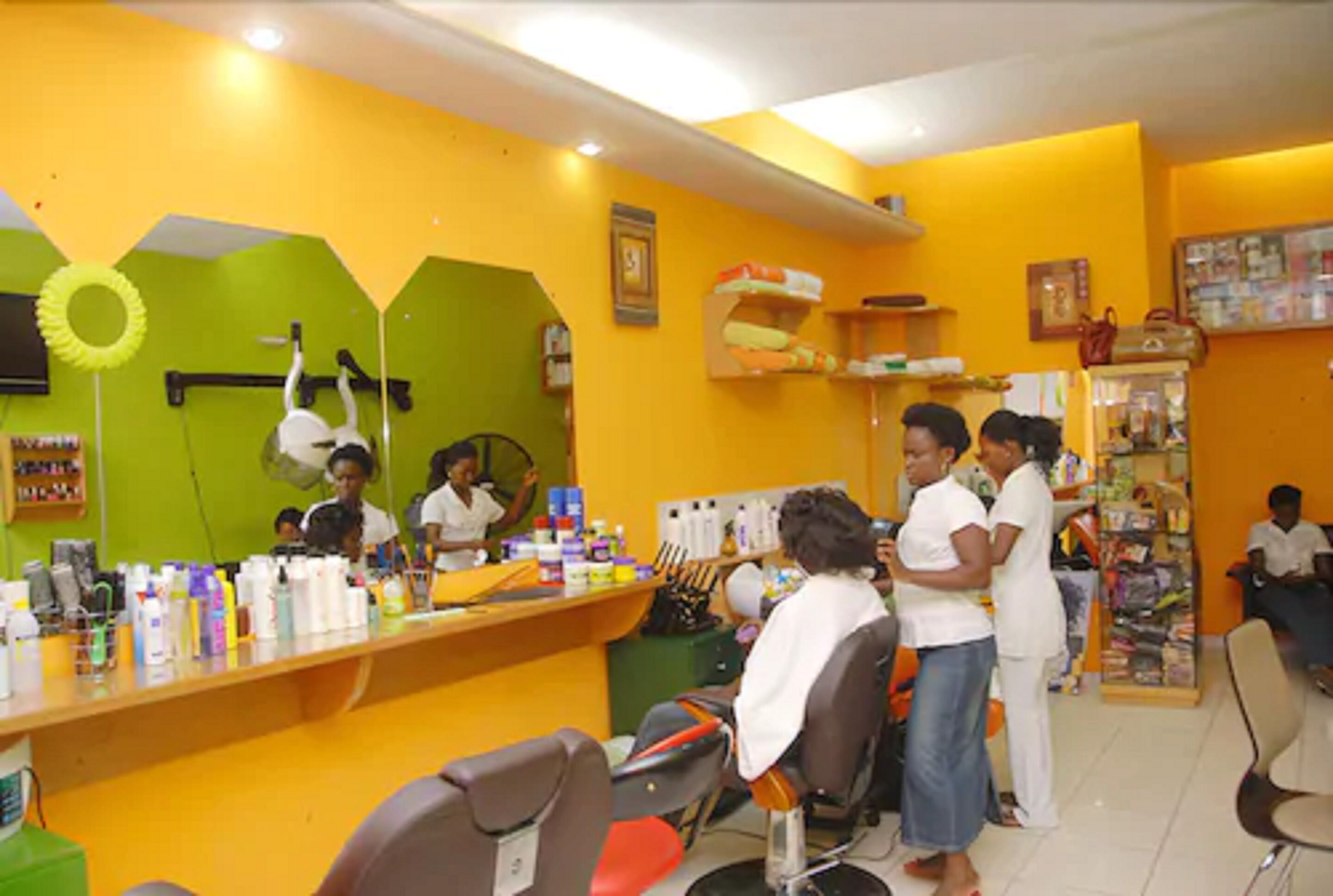 Un salón con mostrador, sillas y varios productos para el cabello.