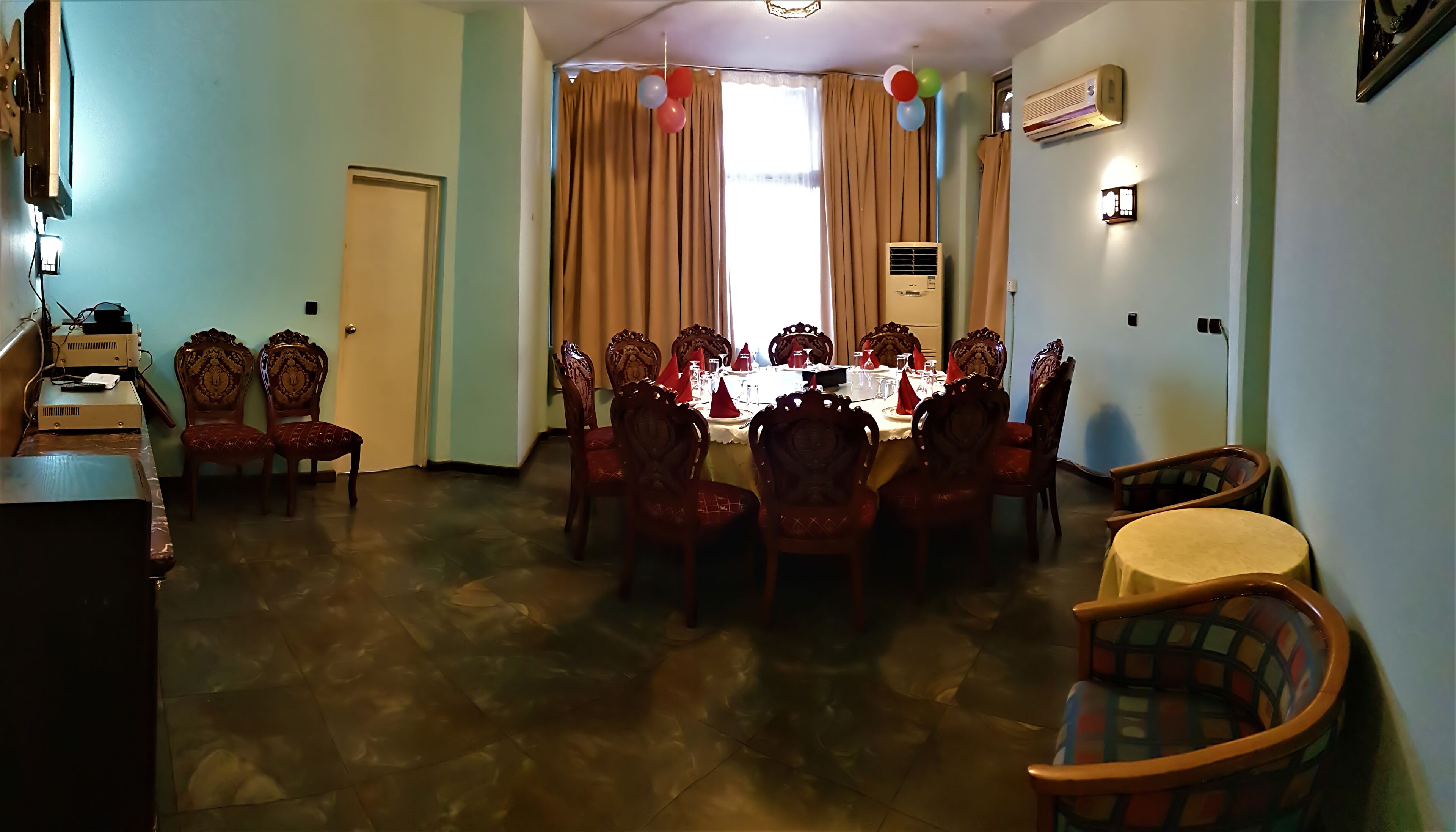 A dining area with a round table set for six, surrounded by ornate chairs.