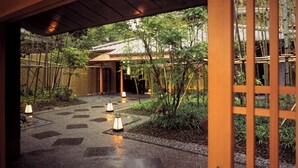 A traditional Japanese-style garden with a pathway leading to a building. - Arima Onsen Kinzan (Kobe)