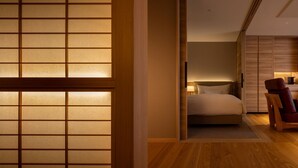 A modern hotel room with a bed, a chair, and a wooden floor. - Arima Onsen Kinzan (Kobe)