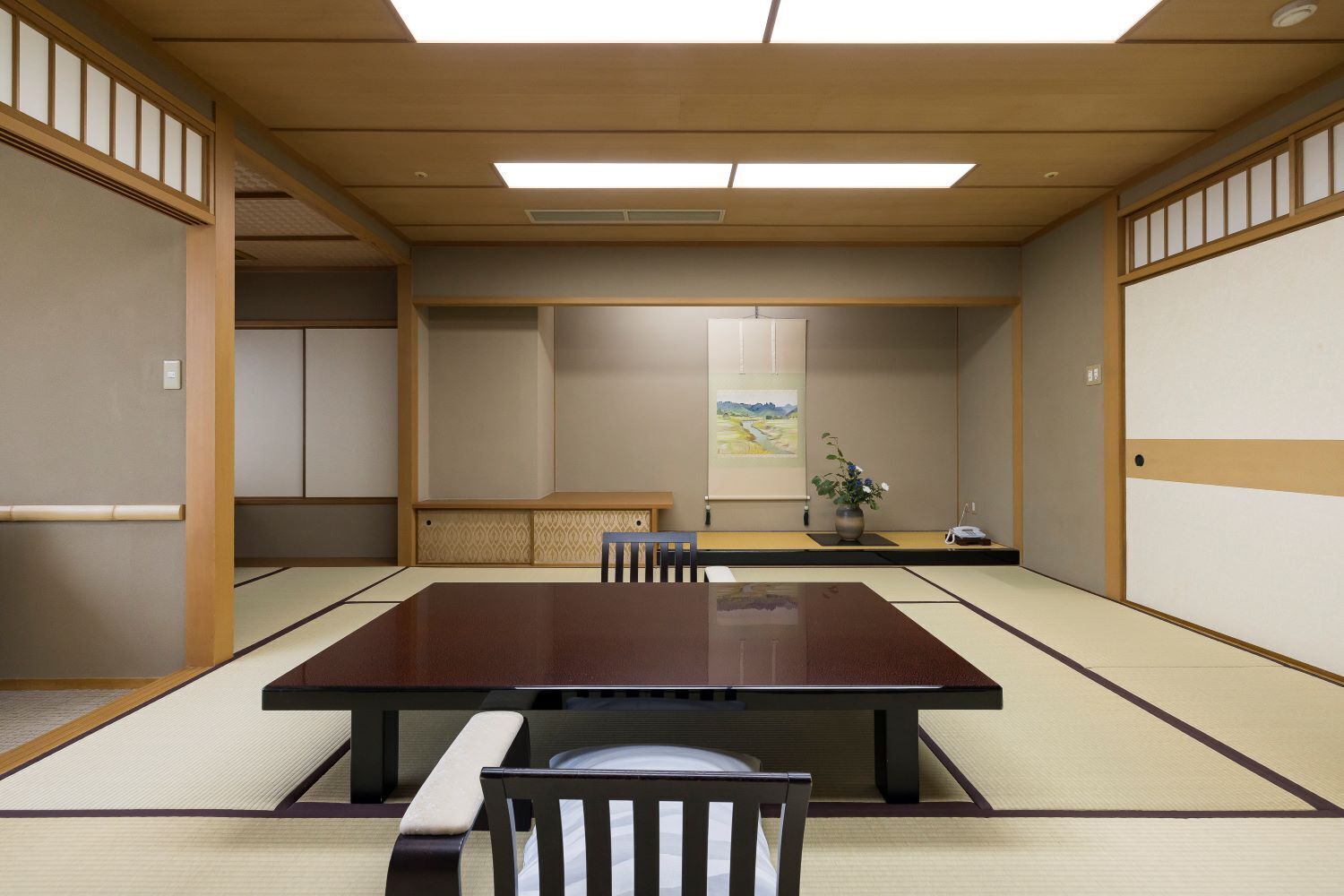 A traditional Japanese meeting room with tatami flooring, a low table, and a single chair.